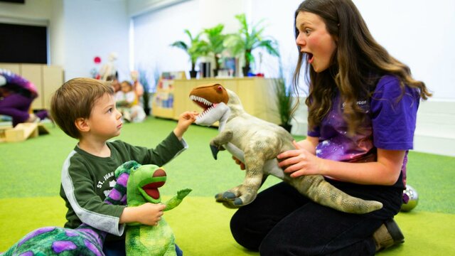 A young boy and a Questacon facilitator play with dinosaurs at Science Time A young boy and a Questacon facilitator play with dinosaurs at Science Time