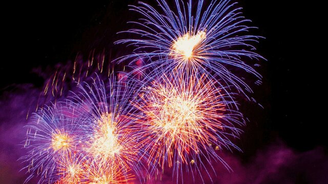 Fireworks bursting with purple and pink colours in in the night sky