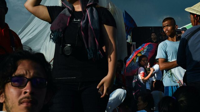 An image of multiple people in a crowd looking around in different directions