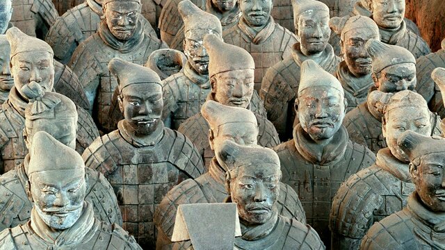 Terracotta warriors in formation, Pit 1, Qin Shihuang's Mausoleum site, Xi'an. A large formation of terracotta warrior statues in uniform standing in rows.
