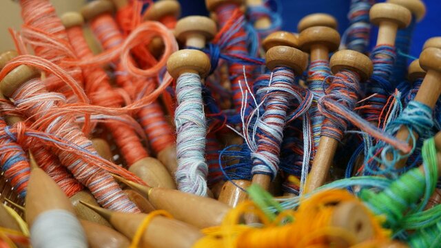Photo courtesy of Australian Tapestry Workshop A close-up image of red and blue yarn on weaving bobbins