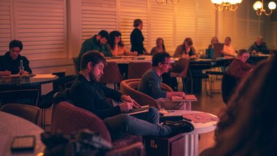 People sitting in front of a stage sketching