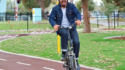 Tony Armstrong smiling while riding a bike