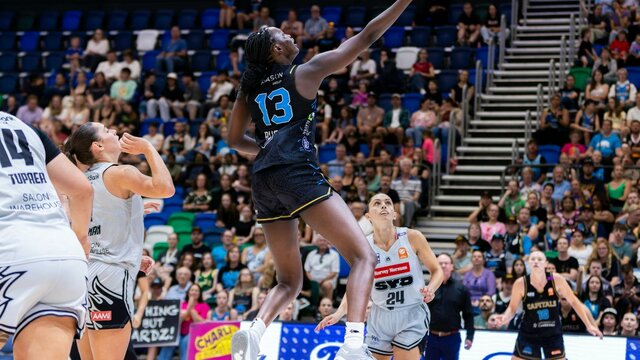 UC Capitals player driving to the basket for a layup during a WNBL game.