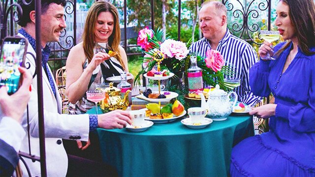 Guests enjoy gin cocktail high tea beneath a canopy at The Underground Gin Garden.