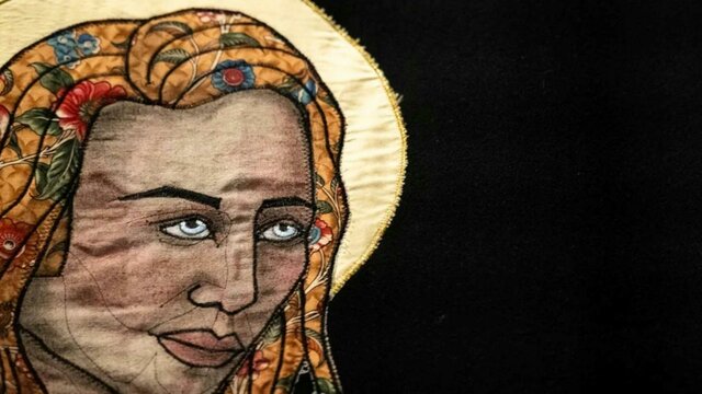 Tal Fitzpatrick | Quietly Seething: Fate, Fury and Transmutation A close up of a quiltyed textile artwork showing a womans face with a yellow halo behind her head