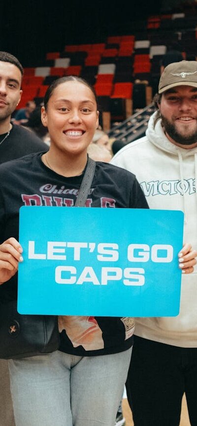 UC Captials fans showing support for the team by holding up a sign that states "let's go Caps" .....