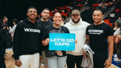 UC Captials fans showing support for the team by holding up a sign that states "let's go Caps" .....