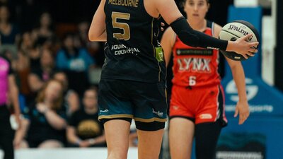 UC Capitals player dribbles the ball up to a Perth Lynx player, squaring up the opposition..........