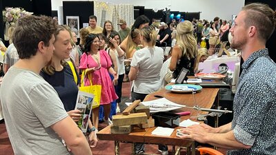 Couples talking with exhibitors at Your Local Wedding Guide Canberra Expo.