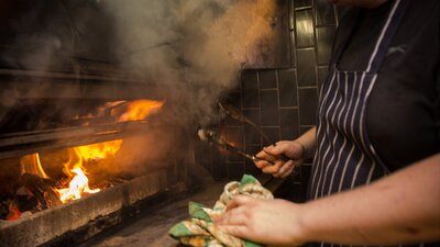 Chef in front of an open fire grill