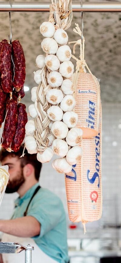 Traditional Italian style cured meats hanging in a delicatessen.