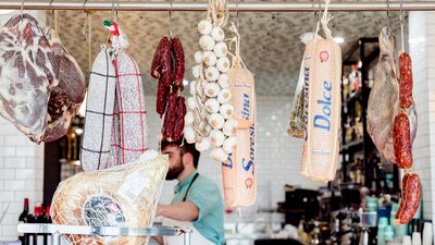 Traditional Italian style cured meats hanging in a delicatessen.