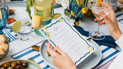 Prix fixe menu on blue and yellow table setting