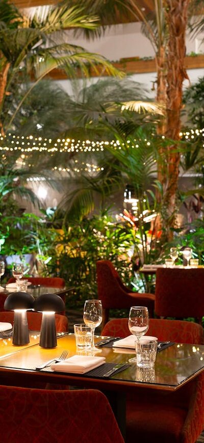 A shot of the Atrium at night - soft warm lights sit on indivual tables