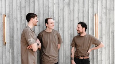 Three men standing and smiling