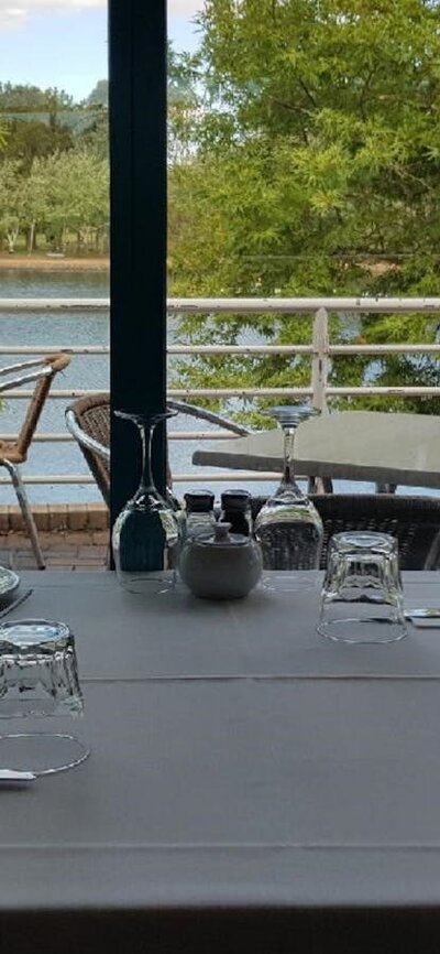 Empty table setting next to window overlooking lake