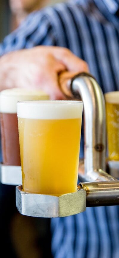 Person holding a tray of beer