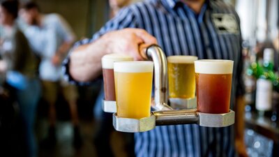 Person holding a tray of beer