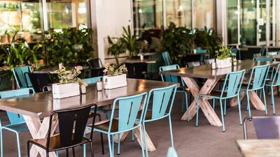 Empty outdoor tables with blue and black seating