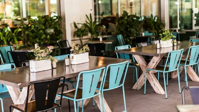 Empty outdoor tables with blue and black seating