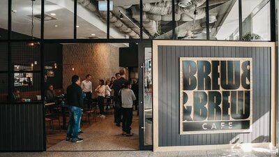 Front of cafe with doors open and people waiting to order