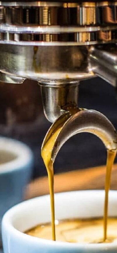 Coffee being brewed into a pale blue coffee cup