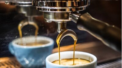 Coffee being brewed into a pale blue coffee cup