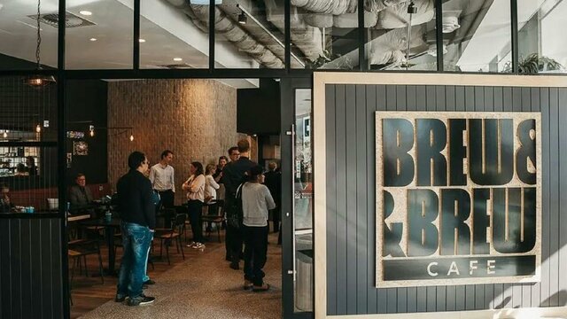 Front of cafe with doors open and people waiting to order