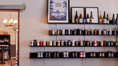 Wall shelf with beer tins sitting on it