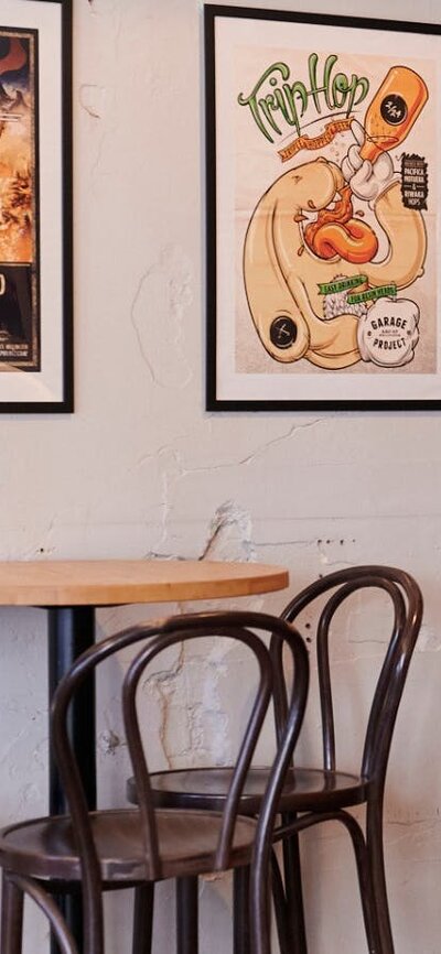 Bar tables against wall with posters in frames hanging on the wall
