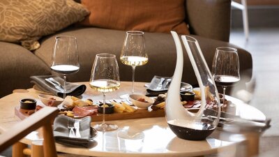 Wine and cheese laid out on a table with wine decanter