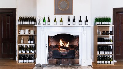 A blazing fire is surrounded by shelves of wines and awards in the historic Old Collector Inn.
