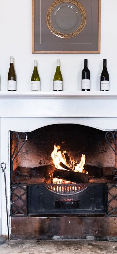 A blazing fire is surrounded by shelves of wines and awards in the historic Old Collector Inn.