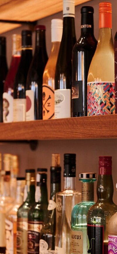 Wall shelf close up full of wine bottles