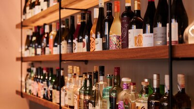 Wall shelf close up full of wine bottles