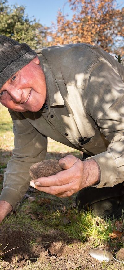 Dick holding a truffle that Bella has located in the soil