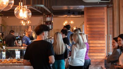 lINE OF PEOPLE WAITING TO COLLECT AND ORDER COFFEE