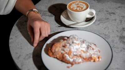 Cup of coffee and plate of pastry on table