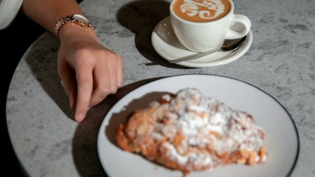 Cup of coffee and plate of pastry on table