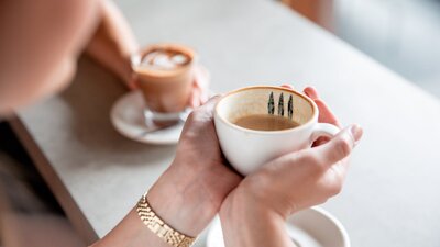 Person holding coffee cup with two hands