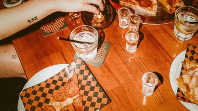 Photo of pizza by the slice and drinks on table