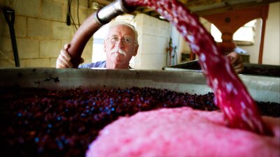 Wine maker Ken Helm at work with the vats