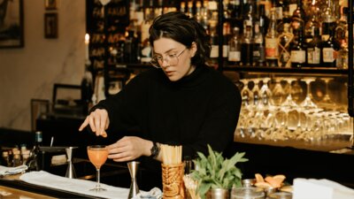 Person making a cocktail at a bar