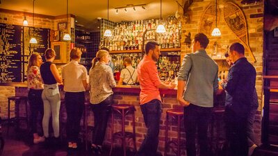 Young people lined up at the bar for cocktails