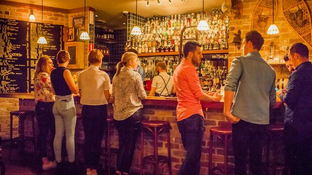 Cocktails a plenty Young people lined up at the bar for cocktails