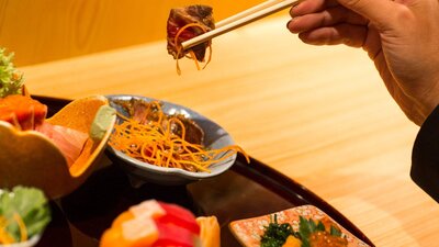 Hand holding japanese food in chopsticks