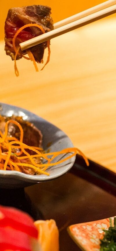 Hand holding japanese food in chopsticks