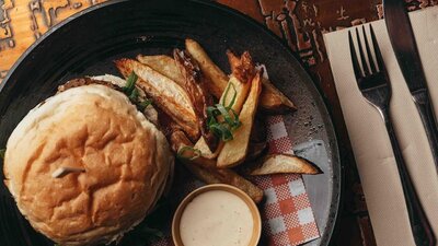 Burger and fries plated on a wooden table