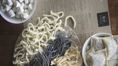 Some fresh pasta next to a menu on a table